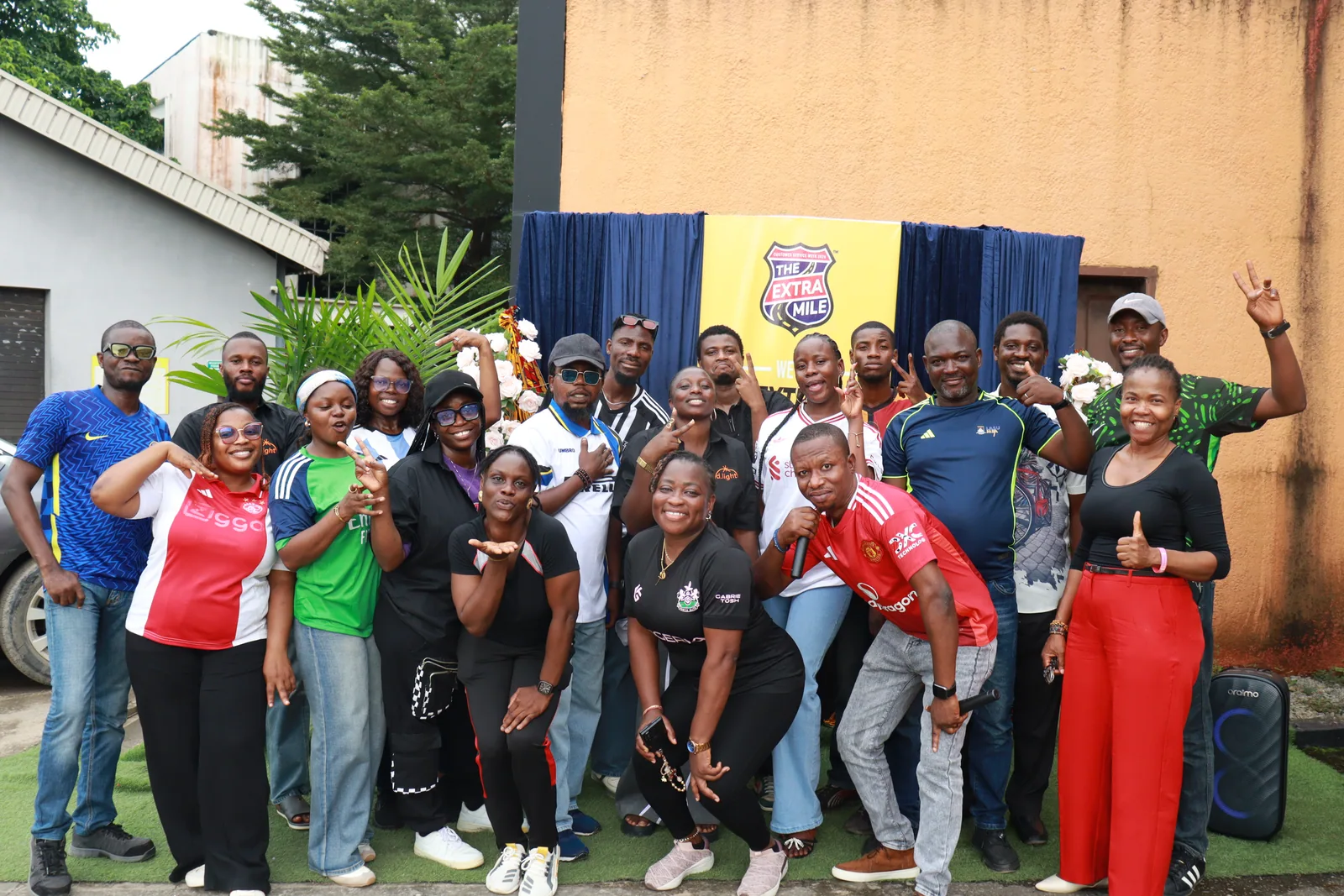 The Nigeria team smiles and raises their hands in a group portrait.