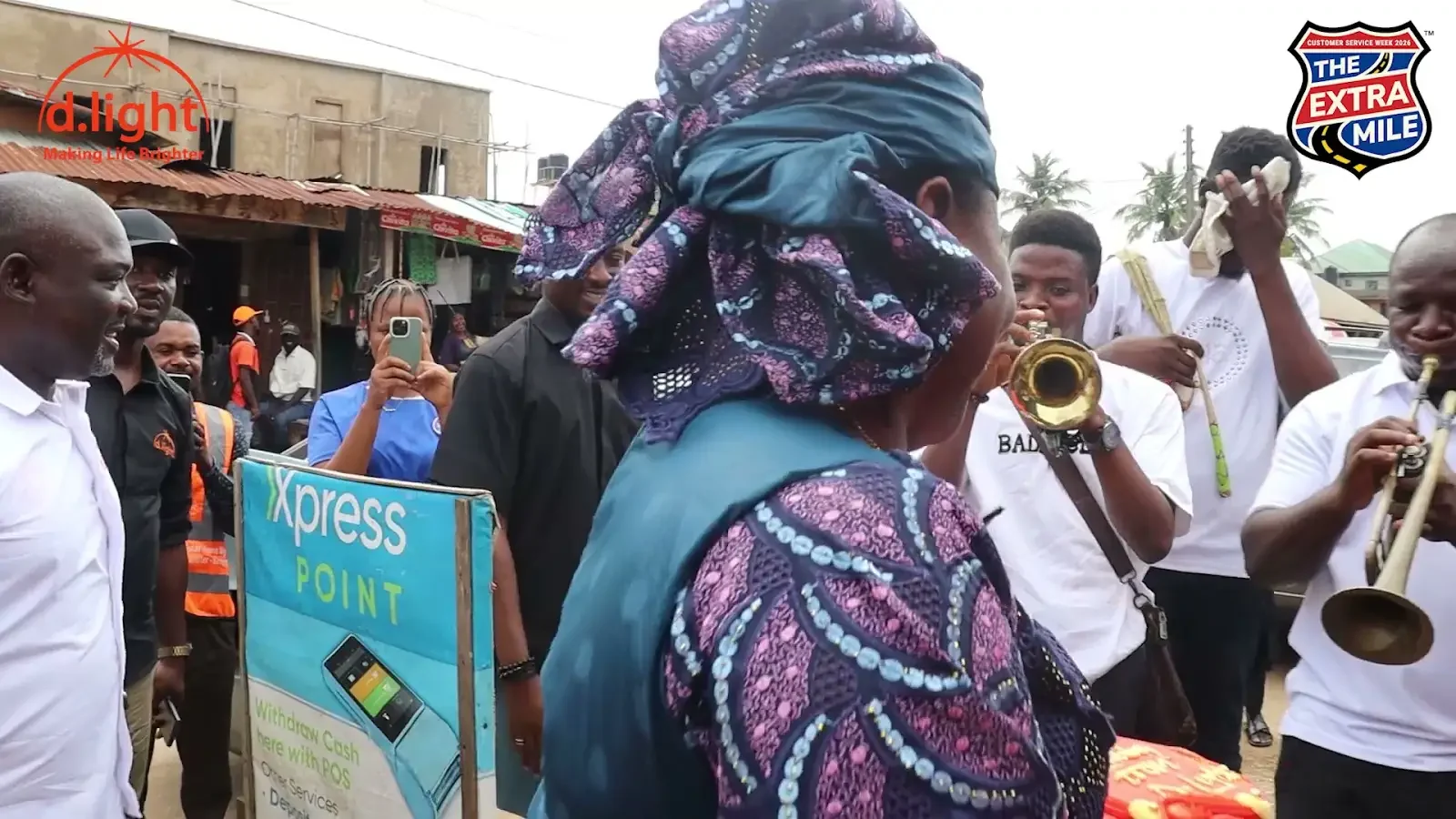 A customer stands beside musicians playing brass instruments; a frame from The birthday surprise.